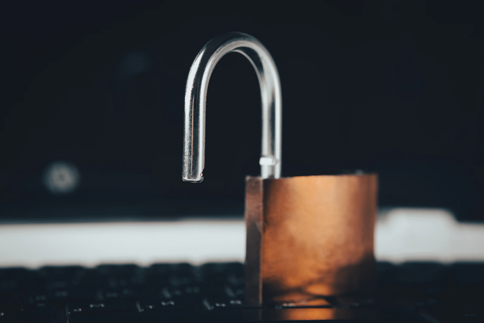 Cadeado aberto sobre o teclado dun portátil, símbolo dunha web de voda sen protección de datos
